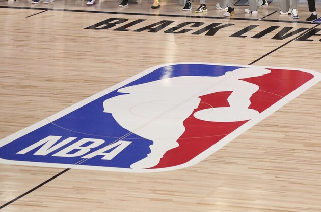 San Antonio Spurs head coach Gregg Popovich stands as other players and staff on the Spurs and the Sacramento Kings kneel around a Black Lives Matters logo on the court before an NBA basketball game, Friday, July 31, 2020, in Lake Buena Vista, Fla. (Kim Klement/Pool Photo via AP)