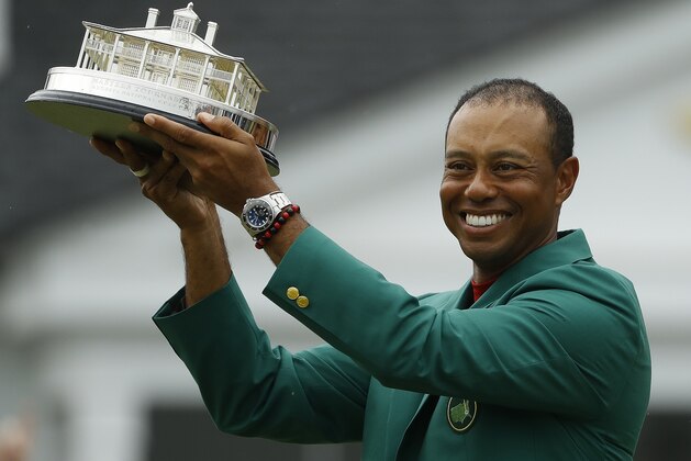 Tiger Woods wears his green jacket holding the winning trophy after the final round for the Masters golf tournament Sunday, April 14, 2019, in Augusta, Ga. (AP Photo/Matt Slocum)