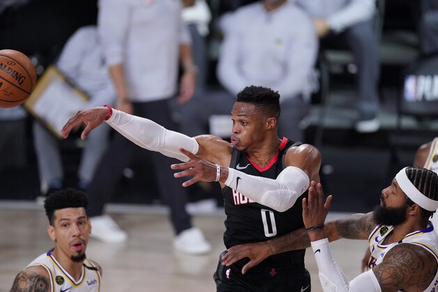 Houston Rockets' Russell Westbrook (0) passes between Los Angeles Lakers' Danny Green, left, and Markieff Morris, right, during the second half of an NBA conference semifinal playoff basketball game Tuesday, Sept. 8, 2020, in Lake Buena Vista, Fla. (AP Photo/Mark J. Terrill)