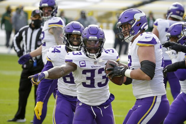 Minnesota Vikings' Ezra Cleveland (72) helps Dalvin Cook (33) celebrate his touchdown run during the second half of an NFL football game against the Green Bay Packers Sunday, Nov. 1, 2020, in Green Bay, Wis. (AP Photo/Mike Roemer)