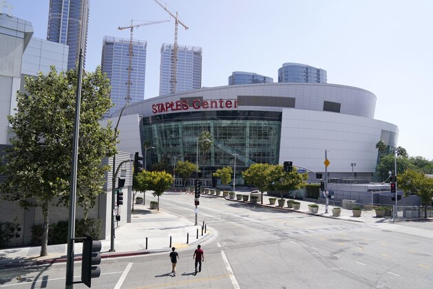 Pedestrians cross an empty street before the 2020 Primetime Emmy Awards at Staples Center, Sunday, Sept. 20, 2020, in Los Angeles. (AP Photo/Chris Pizzello)