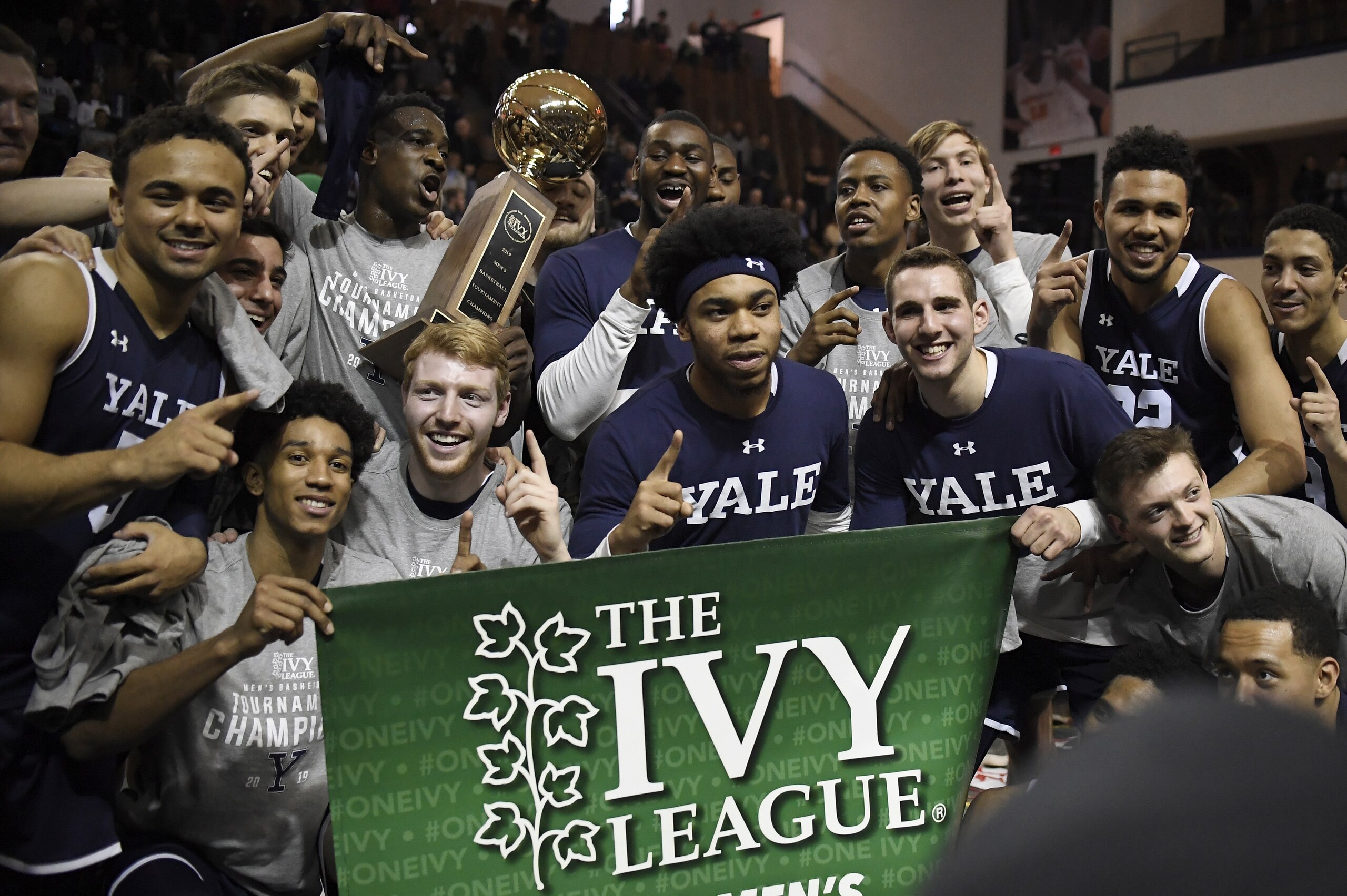 FILE - In this March 17, 2019, file photo, Yale players pose for a photograph with the championship trophy after defeating Harvard in an NCAA college basketball game for the Ivy League championship at Yale University in New Haven, Conn. The Ivy League on Tuesday, March 10, 2020, canceled its men's and women's basketball tournaments because of concerns about the spread of coronavirus. The four-team tournaments were scheduled to be played Friday through Sunday at Lavietes Pavilion in Cambridge. The Ivy League instead will award its automatic NCAA Tournament bids to the regular-season champions, the Princeton women and Yale men. (AP Photo/Jessica Hill, File) FILE - In this March 17, 2019, file photo, Yale players pose for a photograph with the championship trophy after defeating Harvard in an NCAA college basketball game for the Ivy League championship at Yale University in New Haven, Conn. The Ivy League on Tuesday, March 10, 2020, canceled its men's and women's basketball tournaments because of concerns about the spread of coronavirus. The four-team tournaments were scheduled to be played Friday through Sunday at Lavietes Pavilion in Cambridge. The Ivy League instead will award its automatic NCAA Tournament bids to the regular-season champions, the Princeton women and Yale men. (AP Photo/Jessica Hill, File)