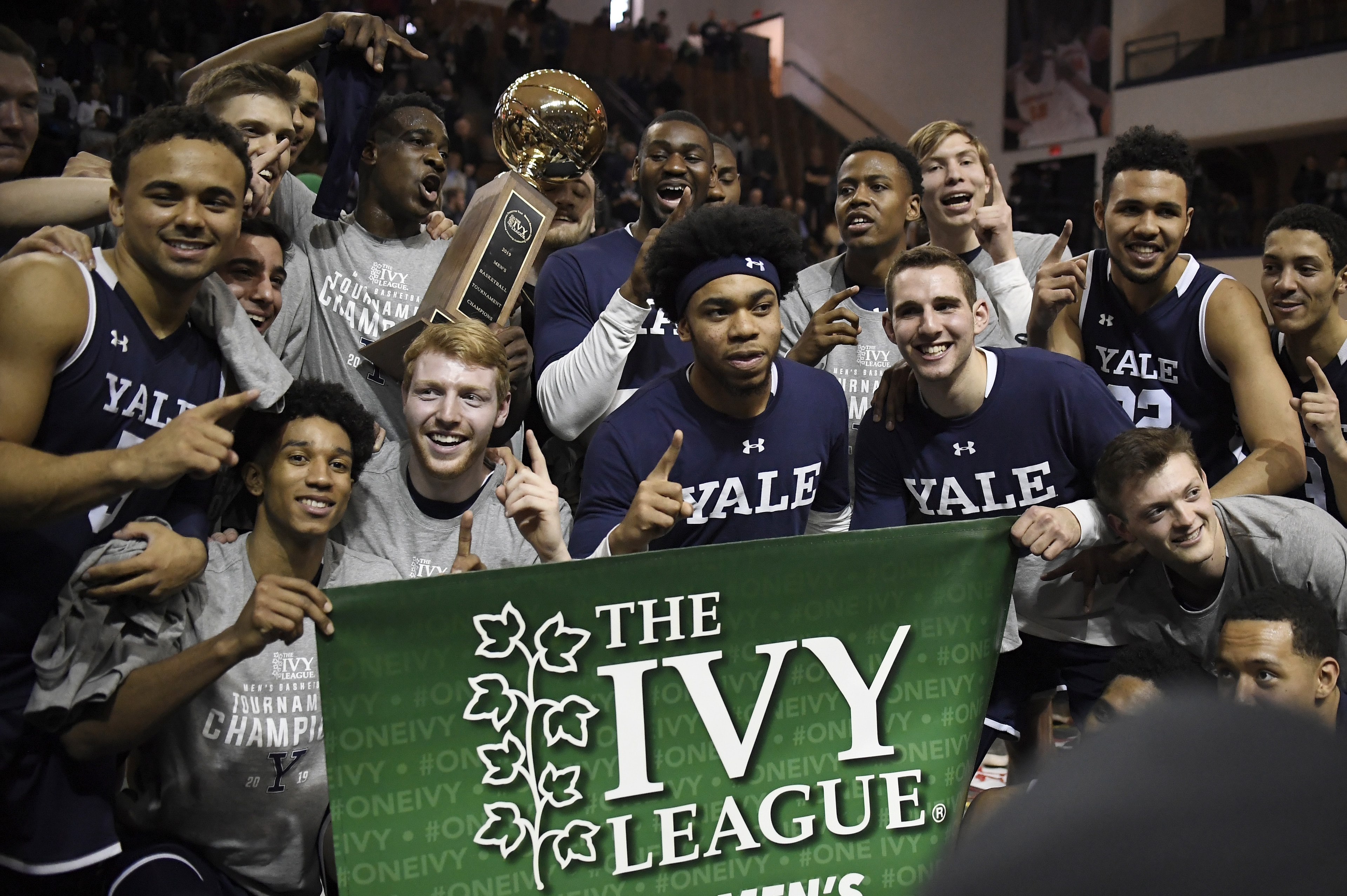 FILE - In this March 17, 2019, file photo, Yale players pose for a photograph with the championship trophy after defeating Harvard in an NCAA college basketball game for the Ivy League championship at Yale University in New Haven, Conn. The Ivy League on Tuesday, March 10, 2020, canceled its men's and women's basketball tournaments because of concerns about the spread of coronavirus. The four-team tournaments were scheduled to be played Friday through Sunday at Lavietes Pavilion in Cambridge. The Ivy League instead will award its automatic NCAA Tournament bids to the regular-season champions, the Princeton women and Yale men. (AP Photo/Jessica Hill, File) FILE - In this March 17, 2019, file photo, Yale players pose for a photograph with the championship trophy after defeating Harvard in an NCAA college basketball game for the Ivy League championship at Yale University in New Haven, Conn. The Ivy League on Tuesday, March 10, 2020, canceled its men's and women's basketball tournaments because of concerns about the spread of coronavirus. The four-team tournaments were scheduled to be played Friday through Sunday at Lavietes Pavilion in Cambridge. The Ivy League instead will award its automatic NCAA Tournament bids to the regular-season champions, the Princeton women and Yale men. (AP Photo/Jessica Hill, File)