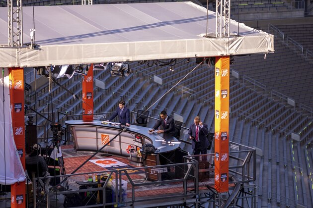 ESPN College Gameday hosts, from left, Rece Davis, David Pollack and Kirk Herbstreit prepare for their live broadcast from Notre Dame Stadium before the NCAA college football game between the Notre Dame and the Clemson in South Bend, Ind. (Matt Cashore/Pool Photo via AP)