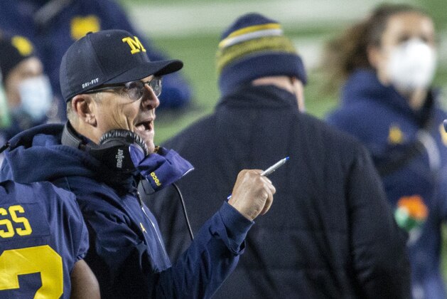 Michigan head coach Jim Harbaugh cheers on his players on the sidelines in the first quarter of an NCAA college football game against Wisconsin in Ann Arbor, Mich., Saturday, Nov. 14, 2020. (AP Photo/Tony Ding)