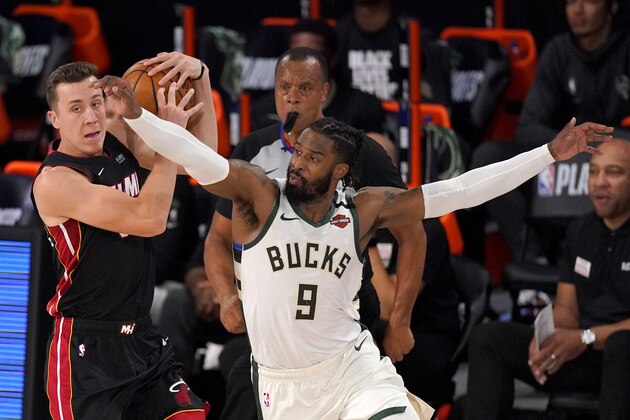 Miami Heat's Duncan Robinson (55) controls the ball as Milwaukee Bucks' Wesley Matthews (9) defends during the first half of an NBA basketball conference semifinal playoff game, Monday, Aug. 31, 2020, in Lake Buena Vista, Fla. (AP Photo/Mark J. Terrill)