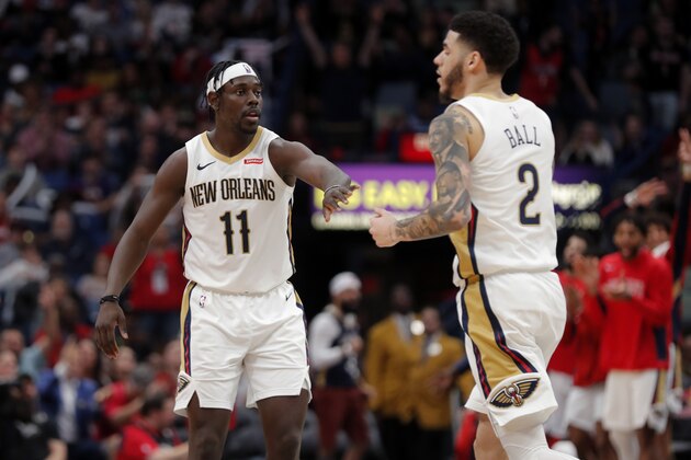 New Orleans Pelicans guard Jrue Holiday (11) and guard Lonzo Ball (2) celebrate after a scoring run in the second half of an NBA basketball game against the Houston Rockets in New Orleans, Sunday, Dec. 29, 2019. The Pelicans won 127-112. (AP Photo/Gerald Herbert)