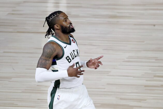Milwaukee Bucks guard Wesley Matthews (9) reacts after making a 3-point basket against the Orlando Magic during the first half  of Game 1 of an NBA basketball first-round playoff series, Tuesday, Aug. 18, 2020, in Lake Buena Vista, Fla. (Kim Klement/Pool Photo via AP)