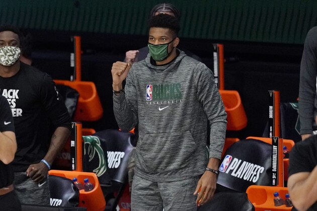Milwaukee Bucks' Giannis Antetokounmpo, center, watches from the bench in the first half of an NBA conference semifinal playoff basketball game against the Miami Heat Tuesday, Sept. 8, 2020 in Lake Buena Vista, Fla. (AP Photo/Mark J. Terrill)