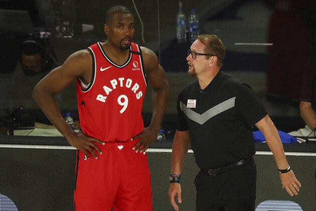 Toronto Raptors center Serge Ibaka (9) speaks with head coach Nick Nurse during a game against the Brooklyn Nets during the first half of Game 4 of an NBA basketball first-round playoff series, Sunday, Aug. 23, 2020, in Lake Buena Vista, Fla. (Kim Klement/Pool Photo via AP)