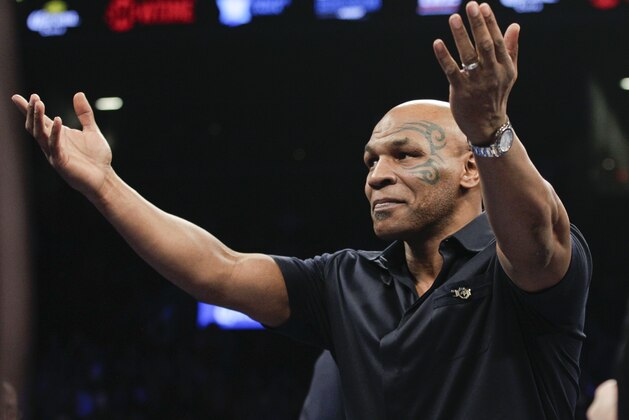 Former boxer Mike Tyson gestures to the crowd before a WBC heavyweight title boxing match between Deontay Wilder and Artur Szpilka, of Poland, Saturday, Jan. 16, 2016, in New York.  (AP Photo/Frank Franklin II)