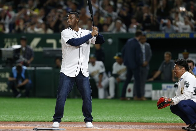 Former Seattle Mariners outfielder Ken Griffey Jr., left, and former Oakland Athletics third baseman Akinori Iwamura attend the ceremonial first pitch before Game 2 of the Major League baseball opening series between the Mariners and the Athletics at Tokyo Dome in Tokyo, Thursday, March 21, 2019. (AP Photo/Toru Takahashi)