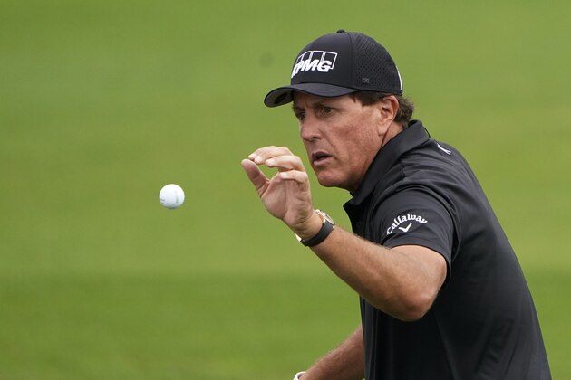 Phil Mickelson catches a ball at the driving range during a practice round for the Masters golf tournament Tuesday, Nov. 10, 2020, in Augusta, Ga. (AP Photo/Chris Carlson)