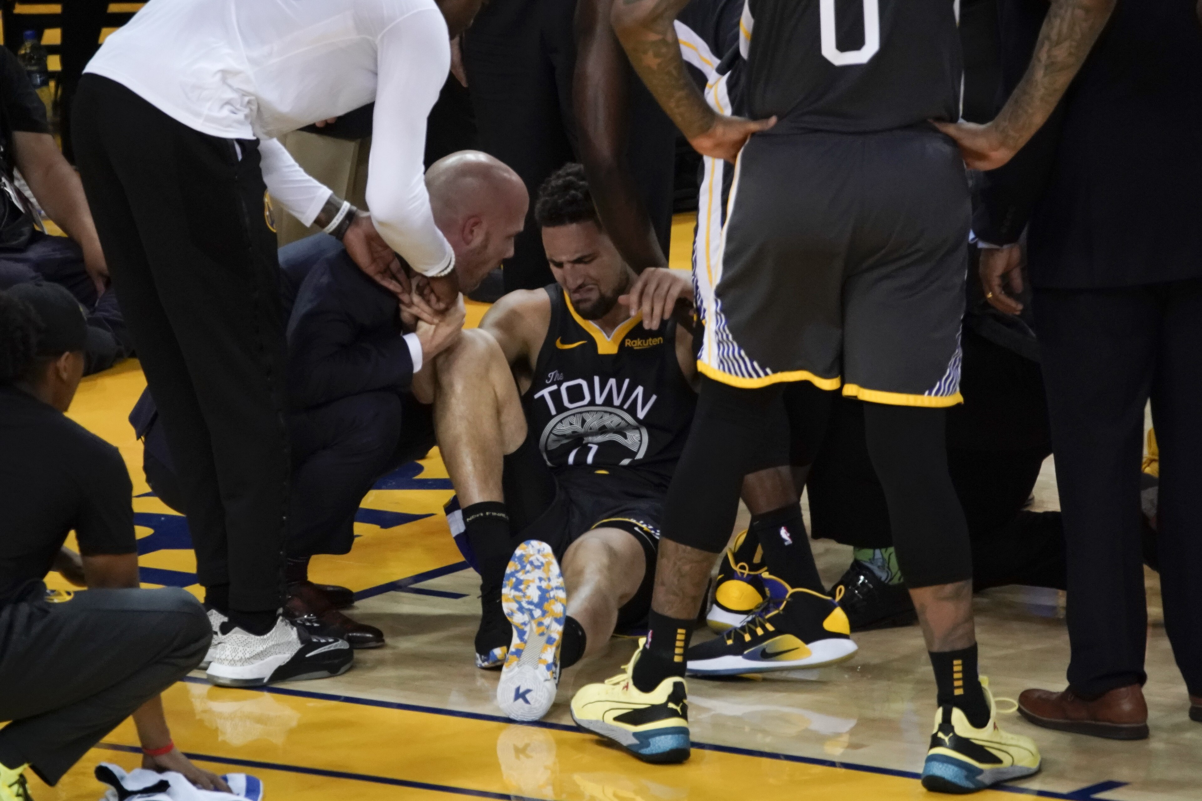 Golden State Warriors guard Klay Thompson, center, is helped up after being injured during the second half of Game 6 of basketball's NBA Finals against the Toronto Raptors in Oakland, Calif., Thursday, June 13, 2019. (AP Photo/Tony Avelar)