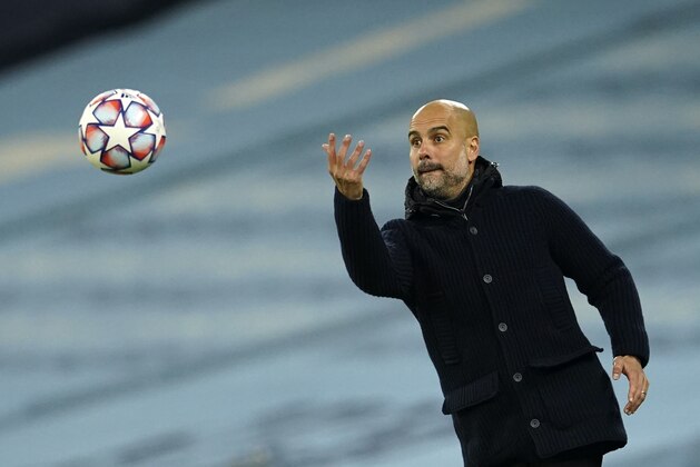 Manchester City's head coach Pep Guardiola throws the ball during the Champions League group C soccer match between Manchester City and Olympiacos at the Etihad stadium in Manchester, England, Tuesday, Nov. 3, 2020. (AP Photo/Dave Thompson)