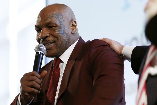 Boxer Mike Tyson is patted on the shoulder by New Jersey Gov. Chris Christie while speaking about his life post prison during the 4th Annual New Jersey Prisoner Reentry Conference, Thursday, April 13, 2017, in Jersey City, N.J. During the event, Tyson presented Christie with a championship belt for his efforts in helping former prisoners reinstall themselves into society. (AP Photo/Julio Cortez)