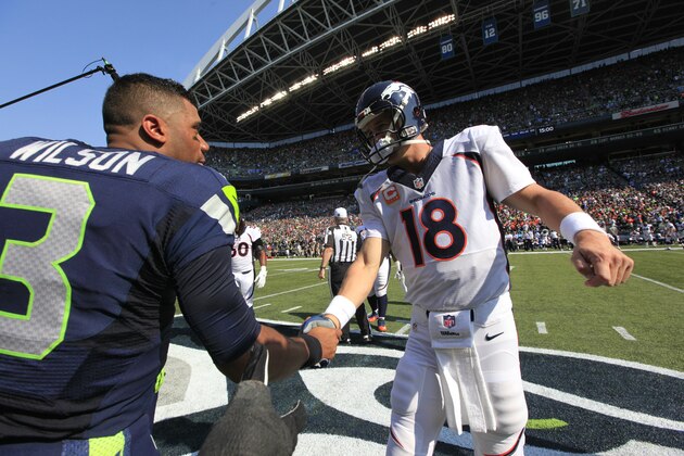 Seattle Seahawks quarterback Russell Wilson (3) and Denver Broncos quarterback Peyton Manning shake hands before a coin flip before an NFL football game, Sunday, Sept. 21, 2014, in Seattle. (AP Photo/Elaine Thompson)