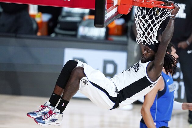 Los Angeles Clippers' Montrezl Harrell (5) hangs on the rim after a dunk during the second half of an NBA basketball first round playoff game against the Dallas Mavericks, Tuesday, Aug. 25, 2020, in Lake Buena Vista, Fla. (AP Photo/Ashley Landis, Pool)