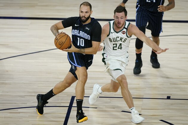 Orlando Magic's Evan Fournier (10) drives past Milwaukee Bucks' Pat Connaughton (24) during the first half of an NBA basketball first round playoff game Monday, Aug. 24, 2020, in Lake Buena Vista, Fla. (AP Photo/Ashley Landis, Pool)