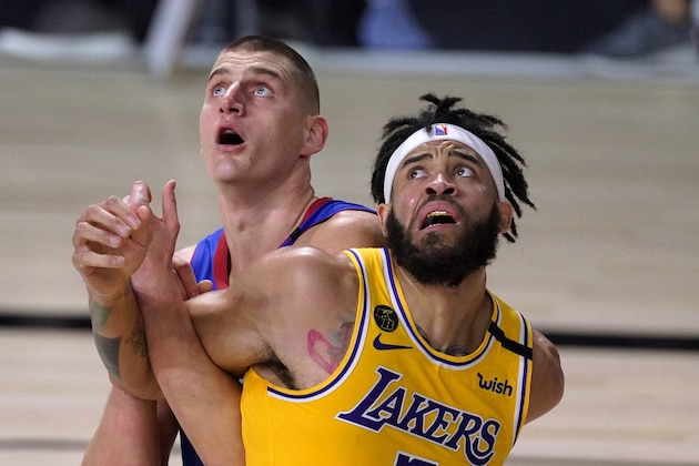 Denver Nuggets' Nikola Jokic, left, and Los Angeles Lakers' JaVale McGee, right, lock up while waiting for a rebound during the first half of Game 1 of the NBA basketball Western Conference final Friday, Sept. 18, 2020, in Lake Buena Vista, Fla. (AP Photo/Mark J. Terrill)