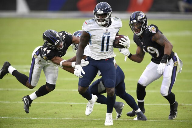 Tennessee Titans wide receiver A.J. Brown (11) runs with the ball as Baltimore Ravens cornerback Marlon Humphrey (44) and linebacker Chris Board (49) try to stop him during the second half of an NFL football game, Sunday, Nov. 22, 2020, in Baltimore. (AP Photo/Nick Wass)