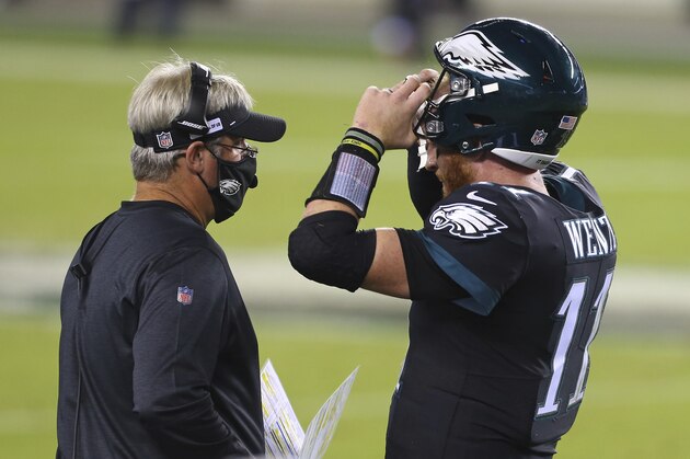 Philadelphia Eagles' head coach Doug Pederson talks with Carson Wentz (11) during a timeout against the New York Giants during an NFL football game, Thursday, Oct. 22, 2020, in Philadelphia. The Eagles defeated the Giants 22-21. (AP Photo/Rich Schultz)
