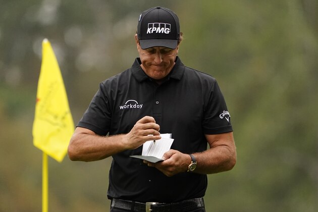 Phil Mickelson fills in his scorecard after putting on the 14th hole during the first round of the Masters golf tournament Friday, Nov. 13, 2020, in Augusta, Ga. (AP Photo/Matt Slocum)
