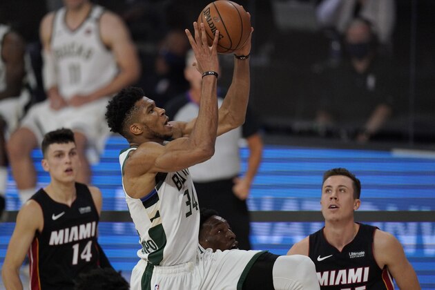Milwaukee Bucks' Giannis Antetokounmpo (34) goes to the basket in front of Miami Heat's Tyler Herro (14) and Duncan Robinson (55) in the second half of an NBA conference semifinal playoff basketball game Friday, Sept. 4, 2020, in Lake Buena Vista, Fla. (AP Photo/Mark J. Terrill)
