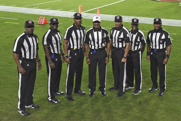 NFL officials, from left, umpire Barry Anderson, side judge Anthony Jeffries, down judge Julian Mapp, referee Jerome Boger, back judge Greg Steed, field judge Dale Shaw (104), line judge Carl Johnson (101) pose for a photo before an NFL football game between the Tampa Bay Buccaneers and the Los Angeles Rams Monday, Nov. 23, 2020, in Tampa, Fla. The game is the first in NFL history to feature an all African-American officiating crew. (AP Photo/Jason Behnken)