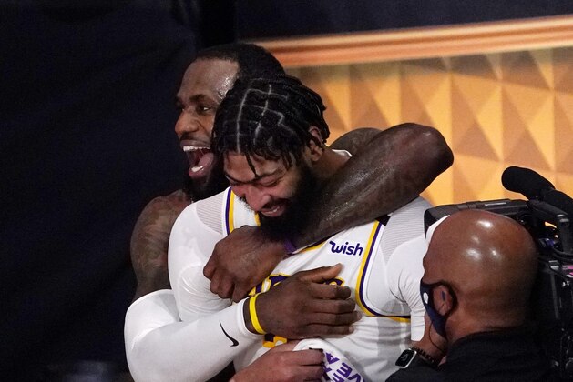 Los Angeles Lakers' LeBron James (23) and Anthony Davis (3) celebrate after the Lakers defeated the Miami Heat 106-93 in Game 6 of basketball's NBA Finals Sunday, Oct. 11, 2020, in Lake Buena Vista, Fla. (AP Photo/Mark J. Terrill)