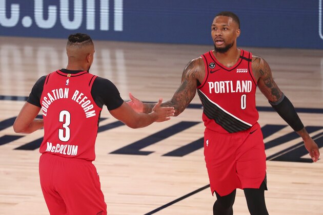 Portland Trail Blazers guard CJ McCollum (3) celebrates with guard Damian Lillard (0) after making a three-point basket against the Los Angeles Lakers during the second half of Game 2 of an NBA basketball first-round playoff series, Thursday, Aug. 20, 2020, in Lake Buena Vista, Fla. (Kim Klement/Pool Photo via AP)