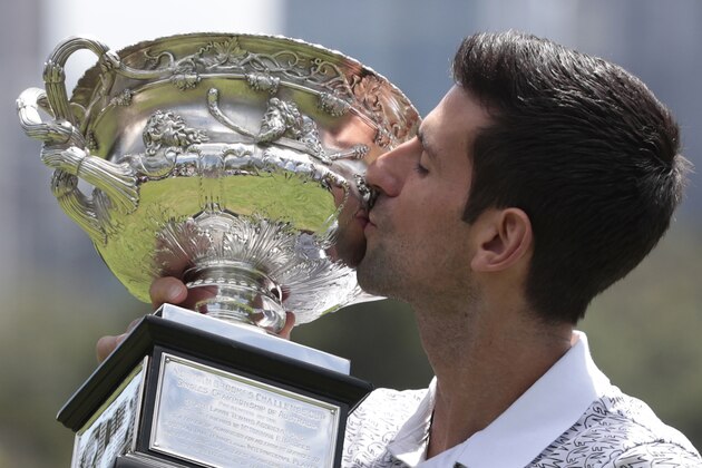Serbia's Novak Djokovic kisses his trophy, the Norman Brookes Challenge Cup, during a photo shoot at Melbourne's Royal Botanic Gardens following his win over Austria's Dominic Thiem in the men's singles final at the Australian Open tennis championships, in Melbourne, Australia, Monday, Feb. 3, 2020. (AP Photo/Dita Alangkara)