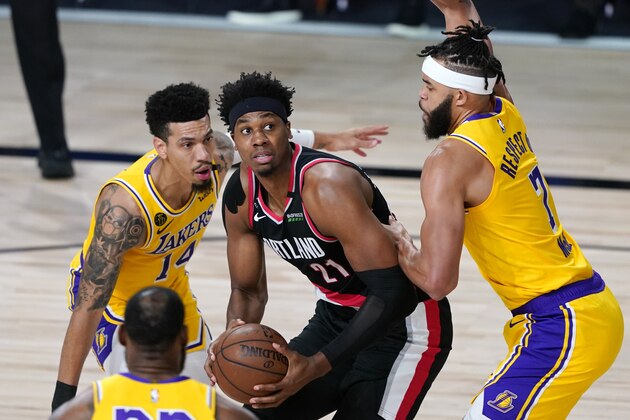 Portland Trail Blazers' Hassan Whiteside (21) is defended by Los Angeles Lakers' Danny Green (14) and JaVale McGee (7) during the first half of an NBA basketball first round playoff game Saturday, Aug. 29, 2020, in Lake Buena Vista, Fla. (AP Photo/Ashley Landis)