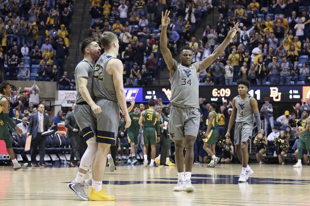 West Virginia guards Jordan McCabe (5), Sean McNeil (22), forward Oscar Tshiebwe (34), and guard Miles McBride (4) celebrate after a score against Baylor during the first half of an NCAA college basketball game Saturday, March 7, 2020, in Morgantown, W.Va. (AP Photo/Kathleen Batten)