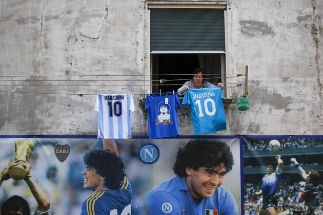 A woman hangs Diego Maradona number 10 jersey's on a drying line, at the popular