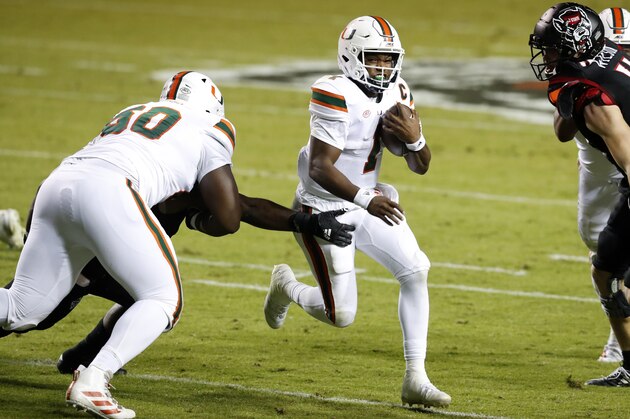 Miami quarterback D'Eriq King (1) runs past North Carolina State linebacker Isaiah Moore, obscured at left, during the first half of an NCAA college football game Friday, Nov. 6, 2020, in Raleigh, N.C. (Ethan Hyman/The News & Observer via AP, Pool)