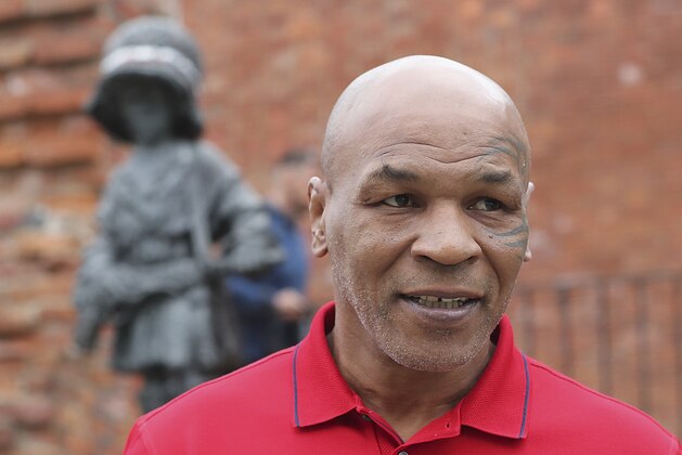 Mike Tyson, an American former heavyweight boxing champion, stands in front of a memorial to Polish suffering during World War II, during a visit to Warsaw, Poland, on Thursday June 27, 2019. (AP Photo/Czarek Sokolowski)