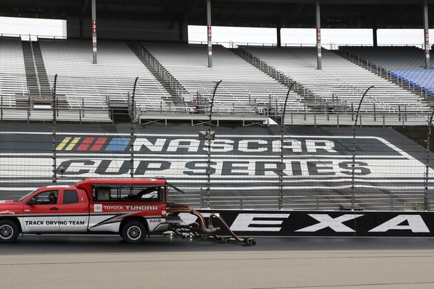 Drying trucks continue to dry the track in an attempt to get it ready for a NASCAR Cup Series auto race after morning rain prevented the 9 a.m. rescheduled start at Texas Motor Speedway in Fort Worth, Texas, Monday, Oct. 26, 2020. (AP Photo/Richard W. Rodriguez)