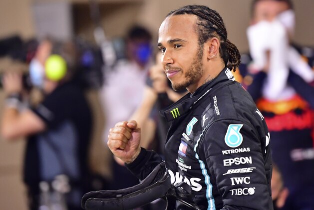 FILE - In this Sunday, Nov. 29, 2020 file photo Mercedes driver Lewis Hamilton of Britain celebrates after wining the Formula One race in Bahrain International Circuit in Sakhir, Bahrain. World champion Lewis Hamilton tested positive for COVID-19 and will miss the Sakhir Grand Prix this weekend, his Mercedes-AMG Petronas F1 Team said Tuesday Dec. 1, 2020. (Giuseppe Cacace, Pool via AP, File)