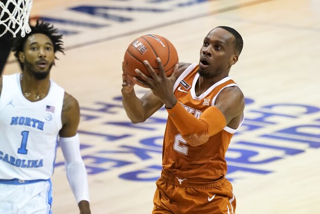 Texas guard Matt Coleman III (2) drives the ball to the basket past North Carolina guard R.J. Davis (4) and North Carolina guard Leaky Black (1) in the first half an NCAA college basketball game for the championship of the Maui Invitational, Wednesday, Dec. 2, 2020, in Asheville, N.C. (AP Photo/Kathy Kmonicek)