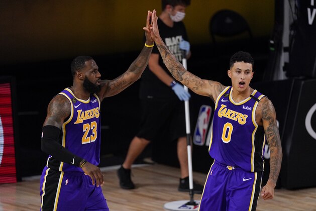 Los Angeles Lakers' LeBron James (23) celebrates with teammate Los Angeles Kyle Kuzma (0) during the first half of an NBA conference semifinal playoff basketball game against the Houston Rockets Friday, Sept. 4, 2020, in Lake Buena Vista, Fla. (AP Photo/Mark J. Terrill)