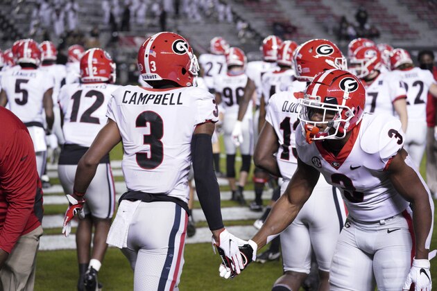 Georgia running back Zamir White, right, greets Tyson Campbell, left, during warm ups before an NCAA college football game against South Carolina Saturday, Nov. 28, 2020, in Columbia, S.C. Georgia won 45-16. (AP Photo/Sean Rayford)