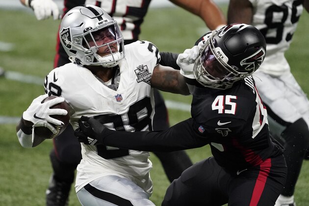 Las Vegas Raiders running back Josh Jacobs (28) stopped by Atlanta Falcons linebacker Deion Jones (45) denying a first down during the first half of an NFL football game, Sunday, Nov. 29, 2020, in Atlanta. (AP Photo/John Bazemore)