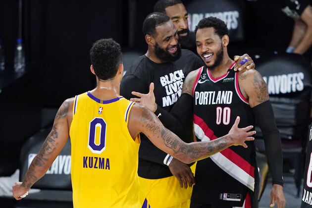 Los Angeles Lakers' Kyle Kuzma (0) and LeBron James, center, greet Portland Trail Blazers' Carmelo Anthony (00) after an NBA basketball first round playoff game Saturday, Aug. 29, 2020, in Lake Buena Vista, Fla. The Lakers won 131-122 to win the series 4-1. (AP Photo/Ashley Landis)