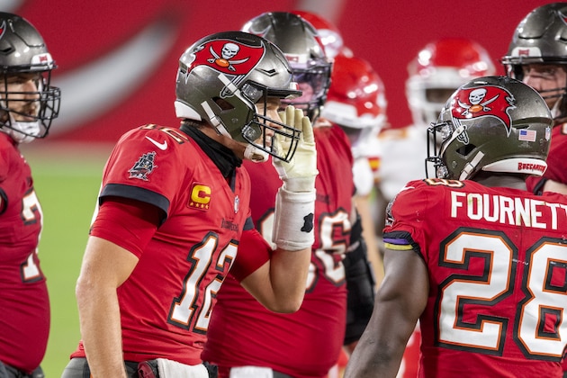 Tampa Bay Buccaneers quarterback Tom Brady (12) yells in the huddle with Tampa Bay Buccaneers running back Leonard Fournette (28)as the Buccaneers take on the Kansas City Chiefs during an NFL football game, Sunday, Nov. 29, 2020, in Tampa, Fla. (AP Photo/Doug Murray)