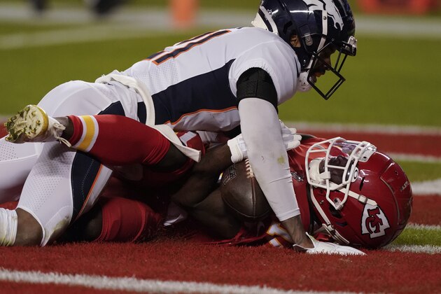 Kansas City Chiefs wide receiver Tyreek Hill (10) tries to catch a pass as Denver Broncos cornerback A.J. Bouye (21) defends in the first half of an NFL football game in Kansas City, Mo., Sunday, Dec. 6, 2020. The pass was called incomplete but replays showed the ball never hit the ground. (AP Photo/Charlie Riedel)