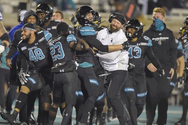 Coastal Carolina coach Josh Miller, right, and Alex Spillum celebrate after an NCAA college football game against BYU Saturday, Dec. 5, 2020, in Conway, S.C. Coastal Carolina won 22-17. (AP Photo/Richard Shiro)