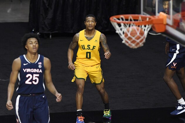 San Francisco's Khalil Shabazz, center, watches his 3-point basket go in with Virginia's Trey Murphy III, left, and Reece Beekman, right, during the second half of an NCAA college basketball game, Friday, Nov. 27, 2020, in Uncasville, Conn. (AP Photo/Jessica Hill)