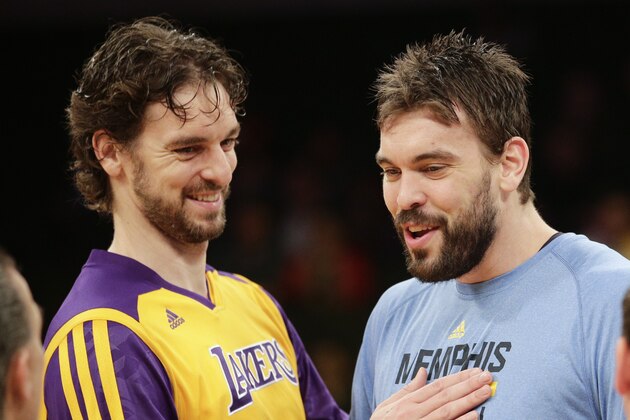 FILE - In this Nov. 15, 2013, file photo, Los Angeles Lakers' Pau Gasol, left, and his brother, Memphis Grizzlies' Marc Gasol talk to referees before an NBA basketball game in Los Angeles. Gregg Popovich will coach the home team while brothers Pau and Marc Gasol will play for Team World in the NBA's first game in Africa. Popovich, the five-time champion from the San Antonio Spurs, will guide Team Africa in the Aug. 1 game in Johannesburg, the league announced Thursday, July 16, 2015.  (AP Photo/Jae C. Hong, File)