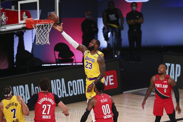 Los Angeles Lakers forward LeBron James (23) shoots a layup over Portland Trail Blazers center Jusuf Nurkic (27) and forward Carmelo Anthony (00) and guard Damian Lillard (0) during the first half in Game 2 of an NBA basketball first-round playoff series, Thursday, Aug. 20, 2020, in Lake Buena Vista, Fla. (Kim Klement/Pool Photo via AP)